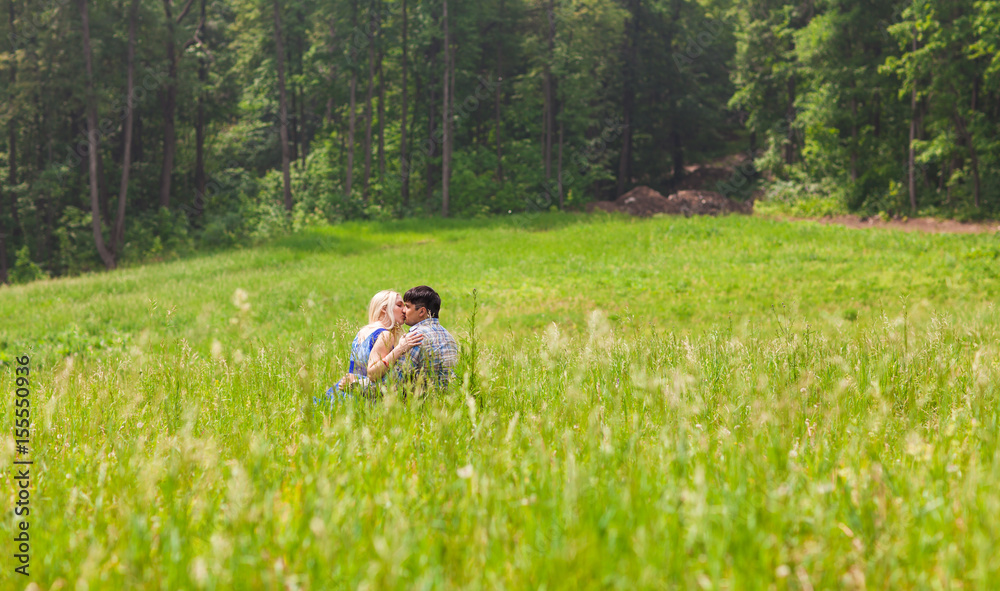 Young kissing couple against the nature Young kissing couple against the nature