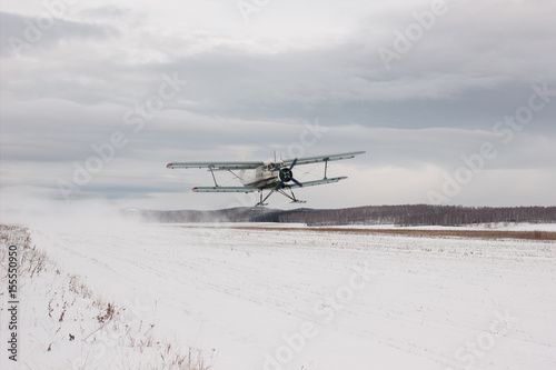 Fototapeta Naklejka Na Ścianę i Meble -  Screw plane pulled away from the runway on a background snow-covered landscape. Front view.