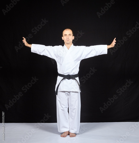 Blocks hands with a black belt athlete trains on a black background