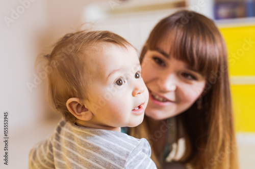 Close-up portrait of happy mother with adorable baby boy indoors