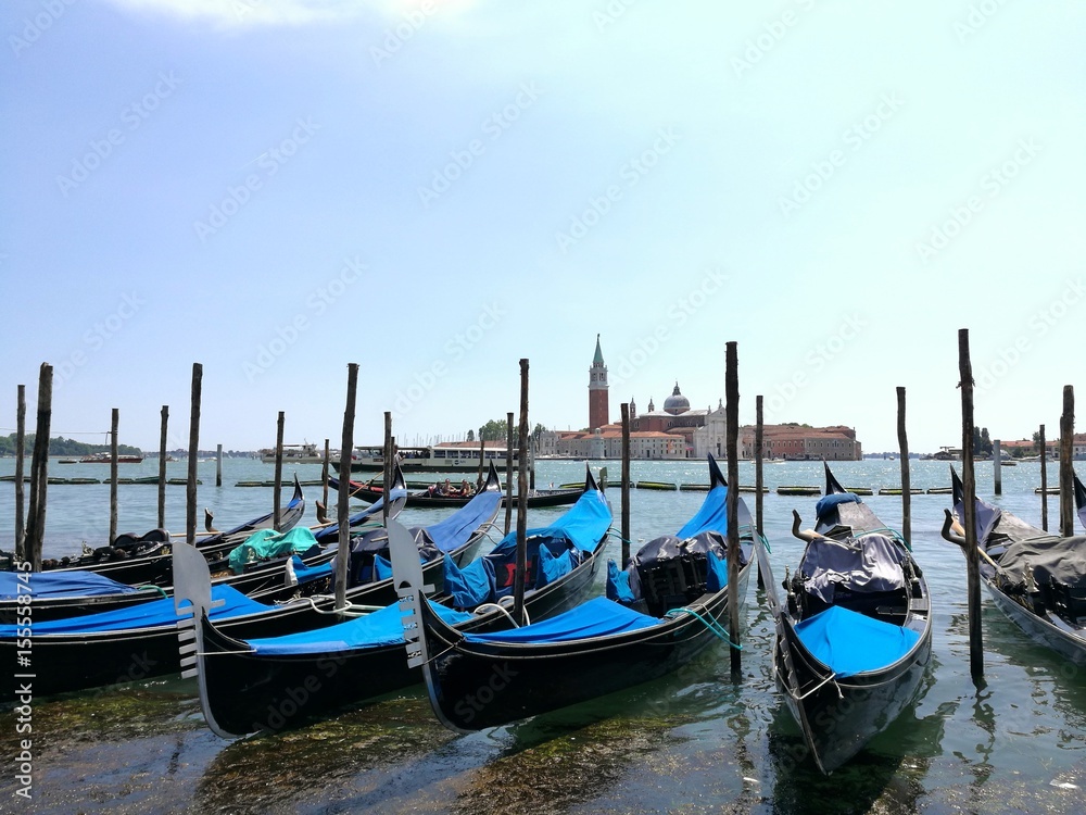 VENICE, ITALY - MAY 18, 2017 : scenic view of gondola in harbor of Venice city during a sunny day