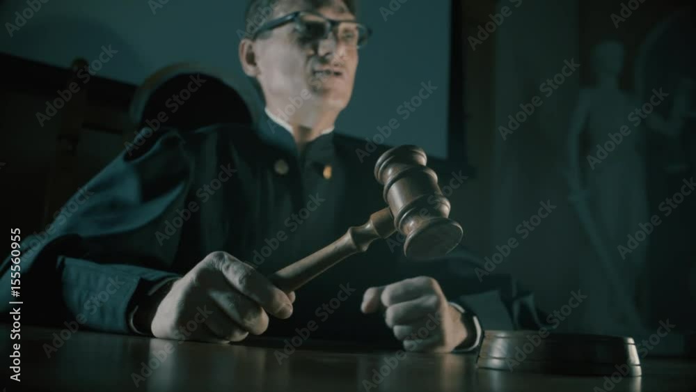a judge with a hammer in his hand in the court room