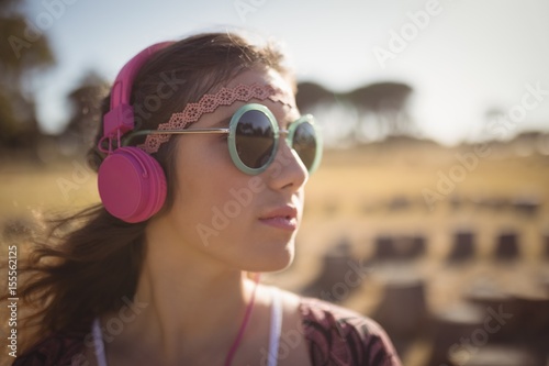 Young woman listening music while wearing sunglasses