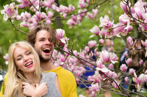 happy couple in love in spring magnolia flowers