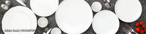 Table setting. Plates and cutlery. On a dark background. Form for advertising banner and restaurants