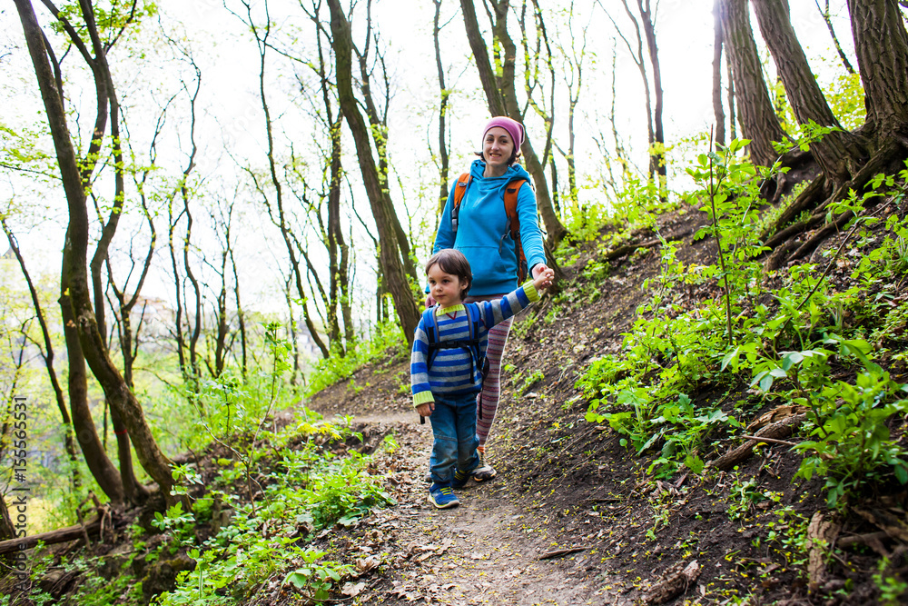 The boy and his mother are walking through the woods. The boy and his mother are walking through the woods.