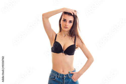 young beautiful girl with natural big breasts in a black bra looks into the camera and holds hand hair