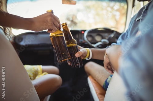 Midsection of friends toasting beer