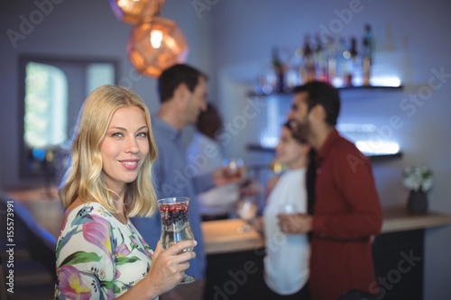 Portrait of smiling woman holding glass of cocktail