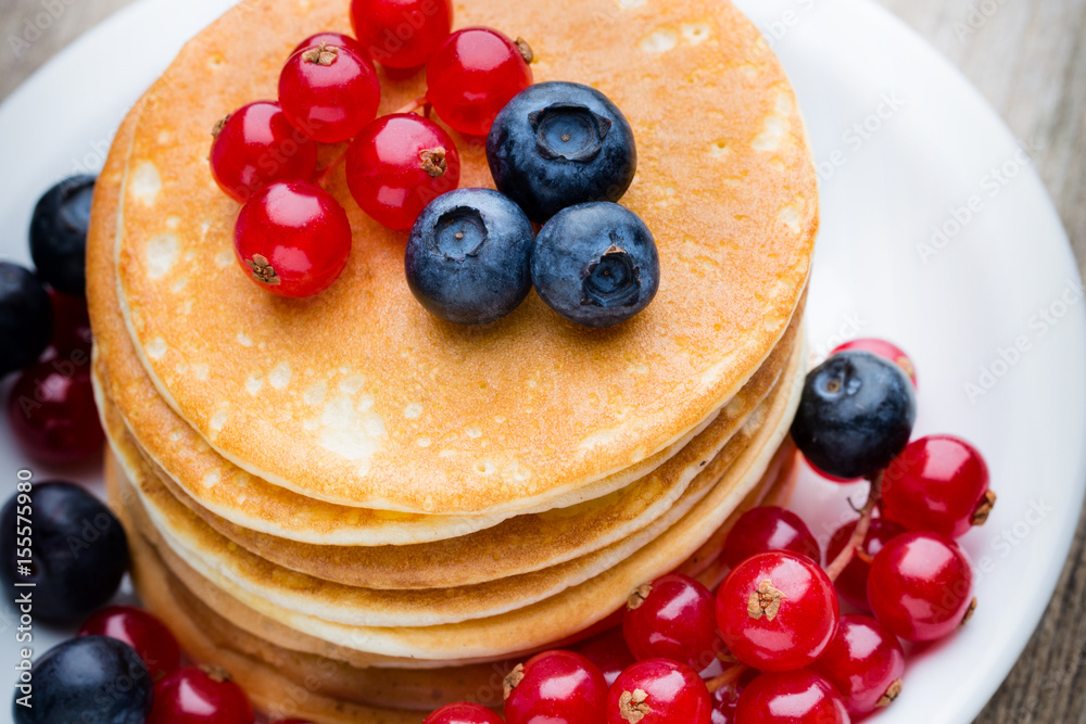 Stack of pancakes with blueberry and fresh berry.