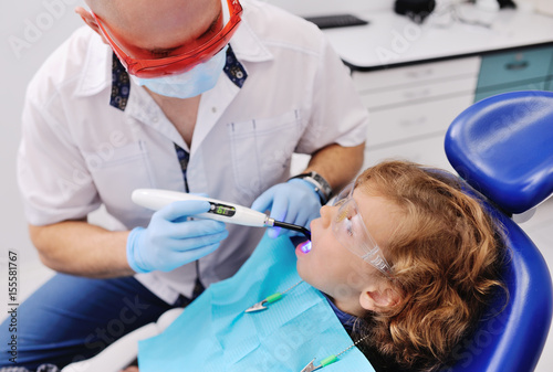 dentist in dental fillings to put glasses baby boy with curly hair