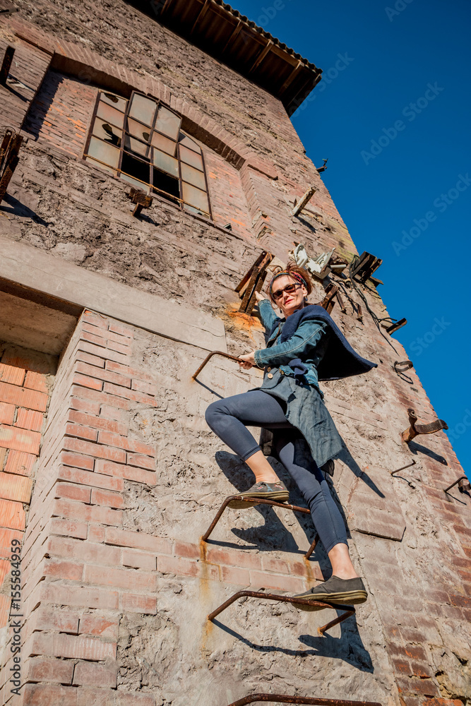 Femme sur l'échelle dans l'usine abandonnée de Toscane