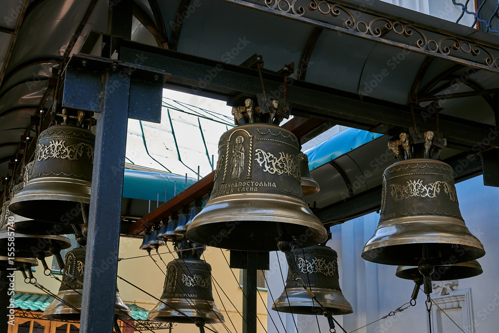 Bells with a beautiful ornament. Bells hung on a metal beam