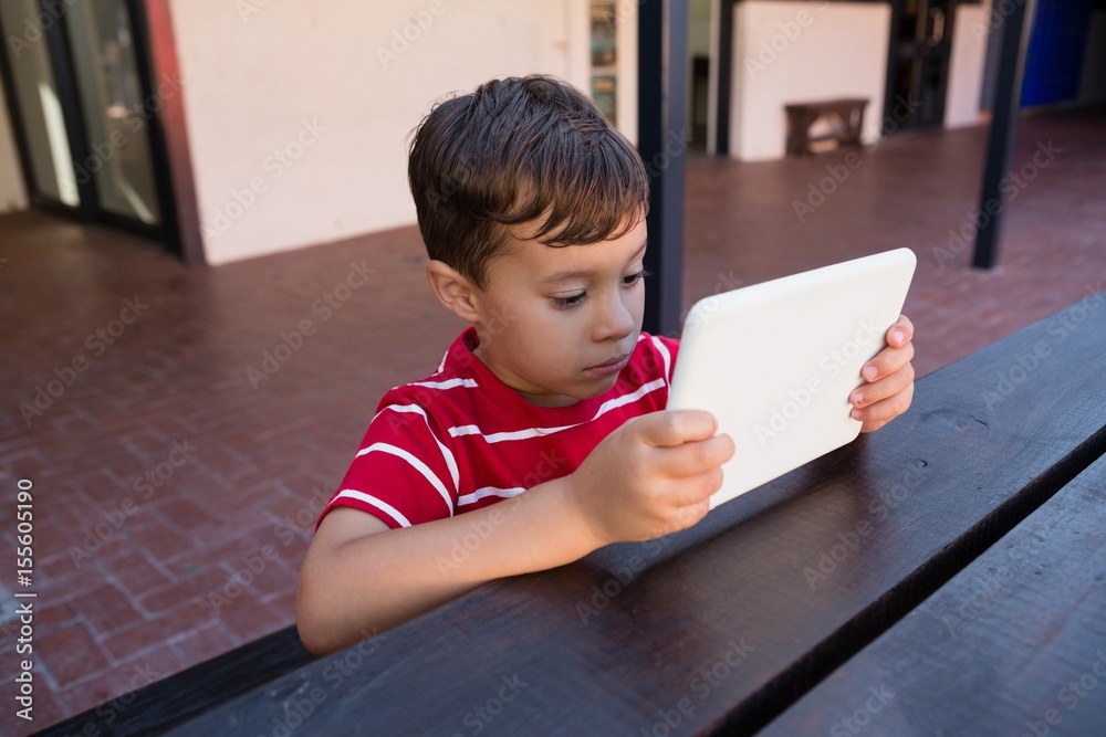 Close up of cute boy using digital laptop while sitting at table Stock ...