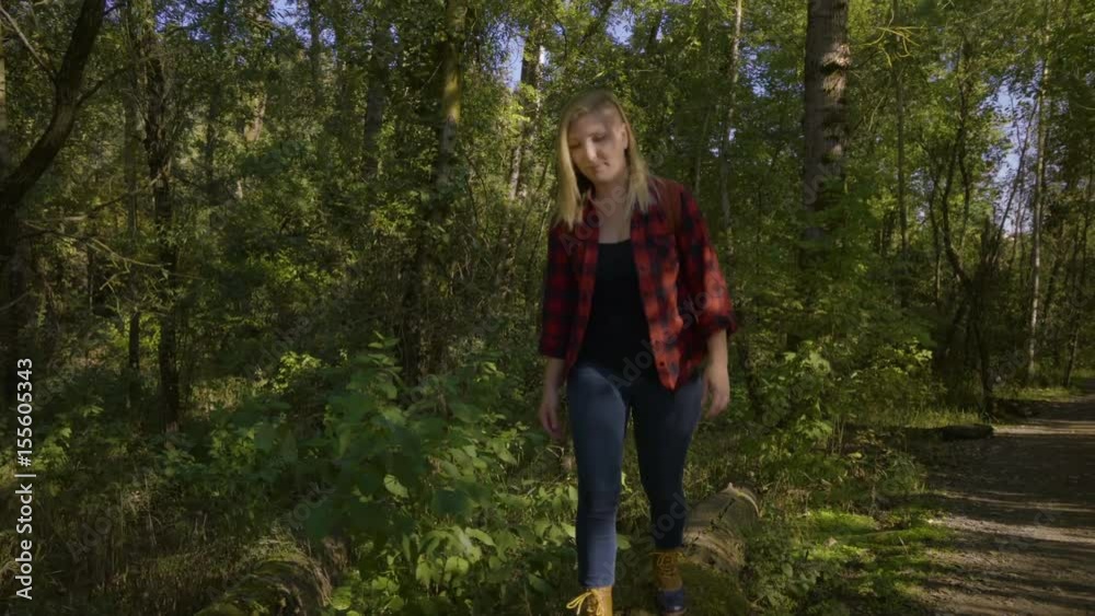 Young Woman Balances On A Log, Reaches The End And Looks Around Then Jumps Off Young Woman Balances On A Log, Reaches The End And Looks Around Then Jumps Off