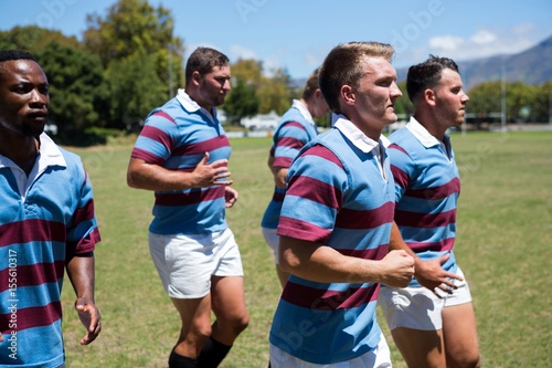 Close up of rugby team jogging at grassy field