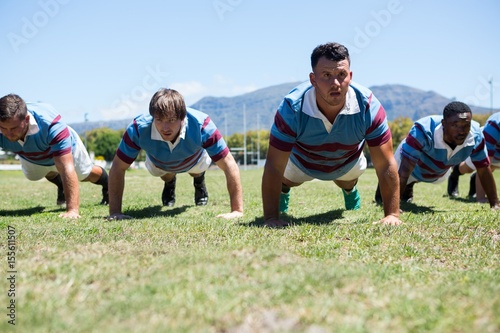 Rugby players doing push up on field © WavebreakMediaMicro