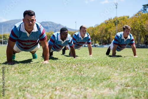 Confident rugby players doing push up at field © WavebreakMediaMicro