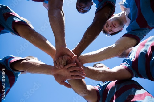 Low angle view of rugby team holding hands