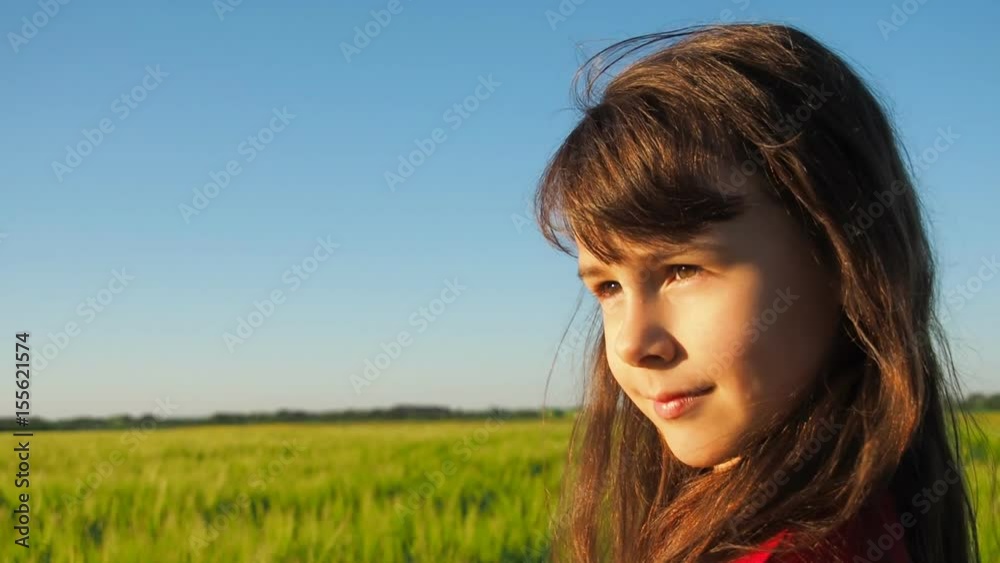 The face of the child is close-up. Little girl on a wheat field. The face of the child is close-up. Little girl on a wheat field.