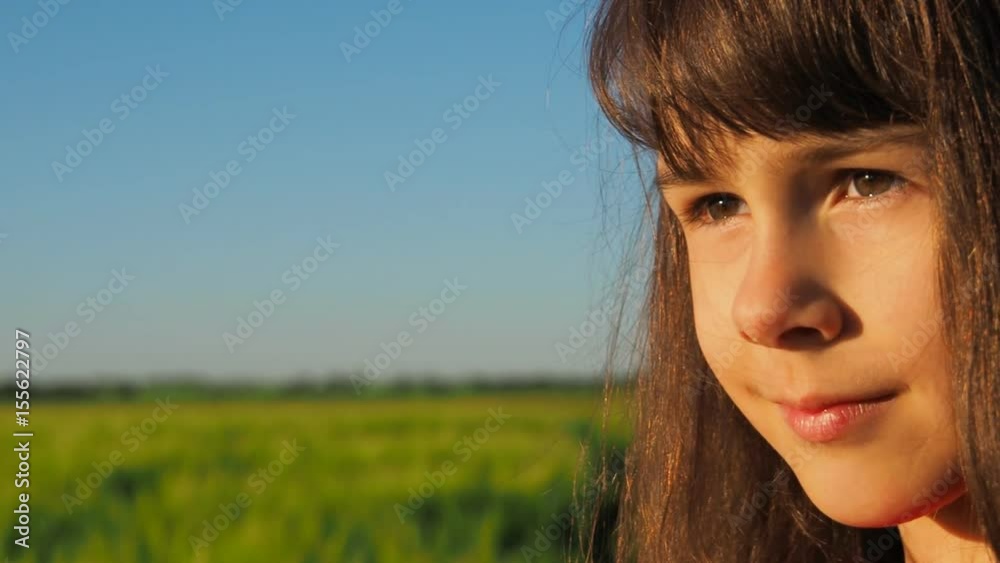 The face of the child is close-up. Little girl on a wheat field. The face of the child is close-up. Little girl on a wheat field.