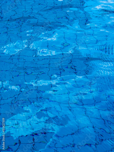 Reflection of sky on the moving water surface in the pool