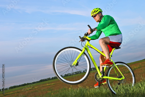 cyclist rides a bicycle in a field
