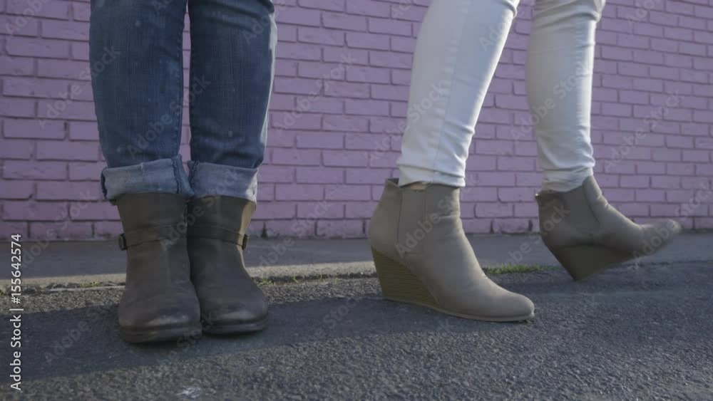 Young Women Stand Side By Side In Front Of Pink Wall And Dance In Unison And Then Do Their Own Moves (Closeup Of Their Feet)