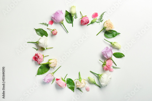 Beautiful flowers and green leaves as floral frame on white background