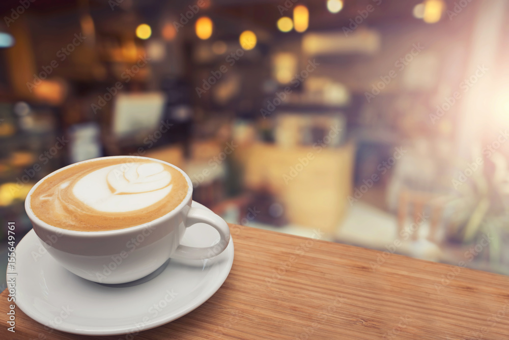 Fototapeta Filiżanka cappuccino na stole, kawiarnia tło, ciepły ton.