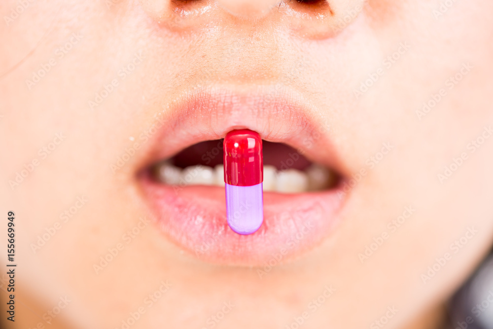 Naklejka premium drug capsule on woman mouth
