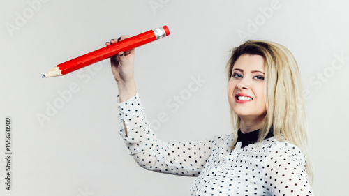 Woman holding big pencil