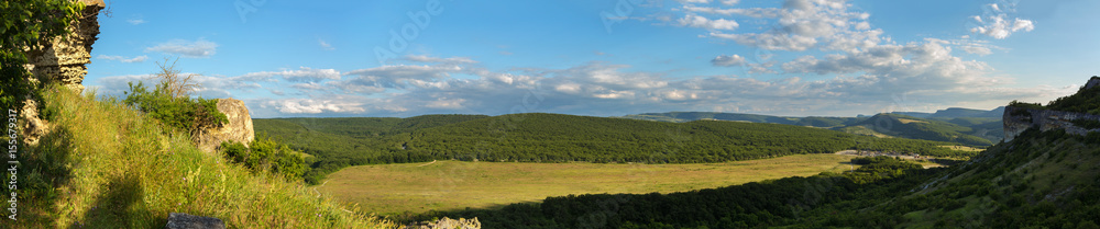 Evening panorama of the green valley. View from the top of cave city Bakla in Crimea.