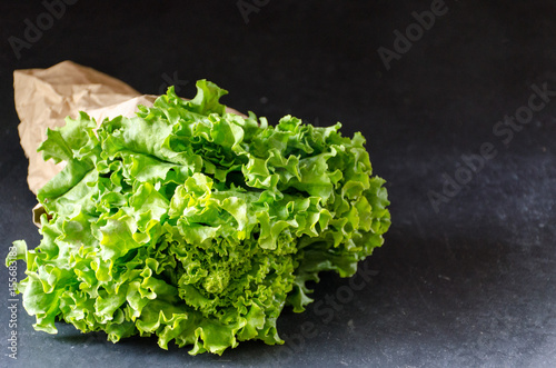 Lettuce in a paper bag on a dark marble background horizontally