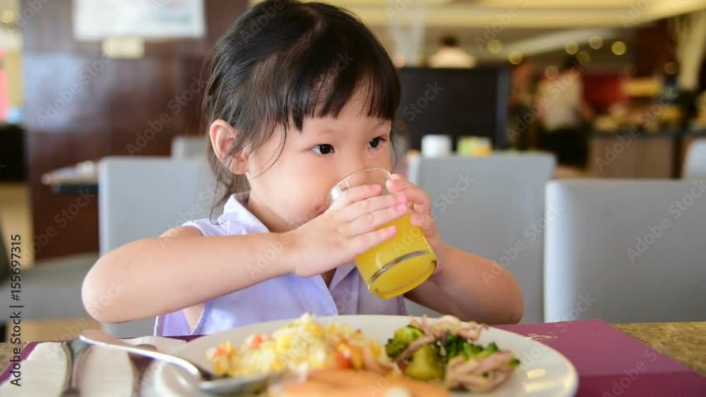 Little asian girl having breakfast on the table Little asian girl having breakfast on the table