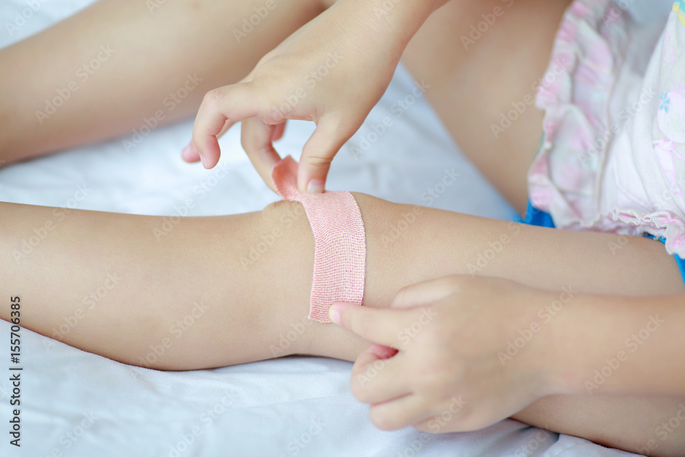 Close Up of child knee with a plaster (for wounds), Selective focus at bandage. Health care and medicine concept. Close Up of child knee with a plaster (for wounds), Selective focus at bandage. Health care and medicine concept.