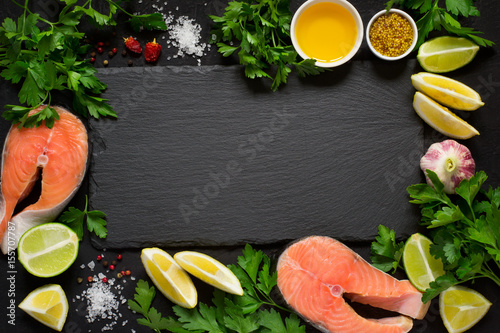 Fresh raw salmon steak And ingredients for preparation around the cutting board. Top view with copy space