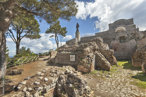 The statue of Virgin Mary with Jesus and church on the ruins of Tiberius Villa Jovis on island Capri, Italy