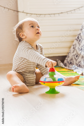 Cute baby boy toddler playing with toy indoors