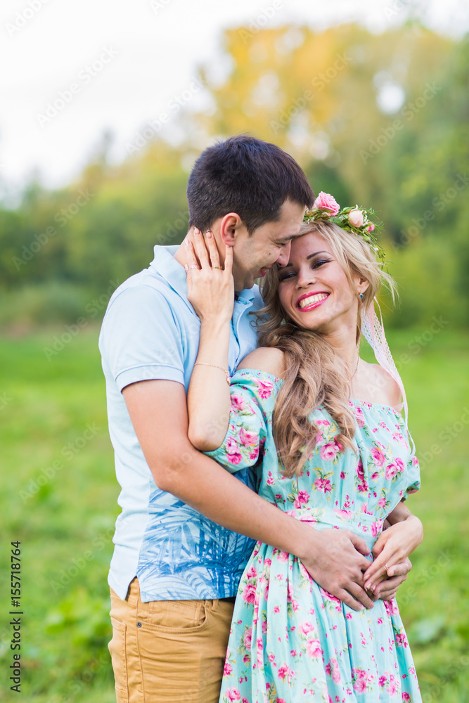 Fototapeta premium Couple embracing on nature. Portrait of Young romantic man and woman standing and hugging each other with tenderness outdoors. Young love concept.