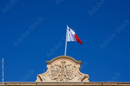 Maltese flag and coast of arms on top of the Auberge de Castille in Castille Square, Valletta, Malta. photo