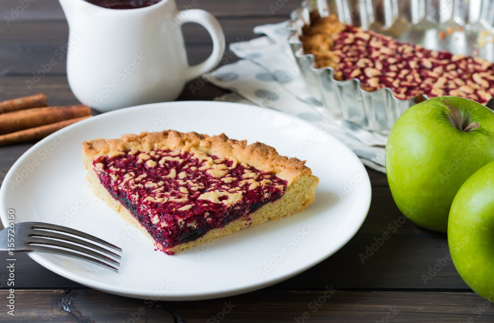 Pie with apple and berry jam on a dark wooden background
