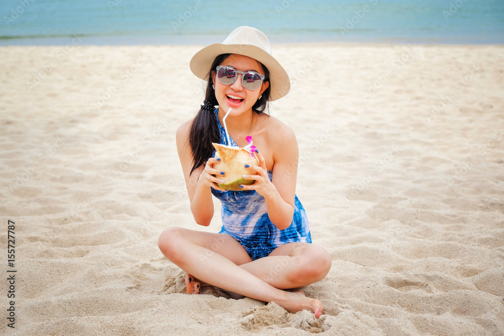Happy young woman with fresh coconut water on the beach Happy young woman with fresh coconut water on the beach