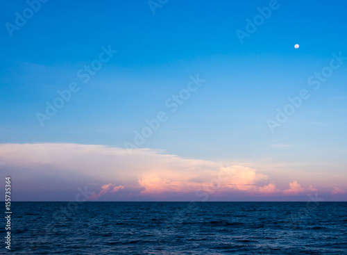 Clouds and moon in sunset sky over sea © Satakorn