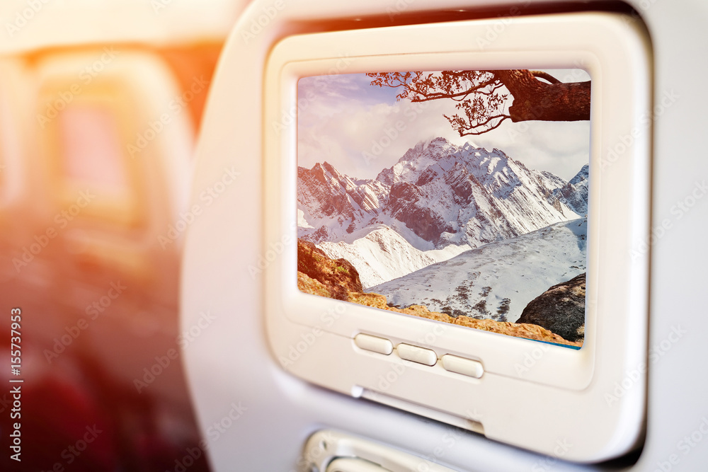 Aircraft monitor in front of passenger seat showing high snow moutain view