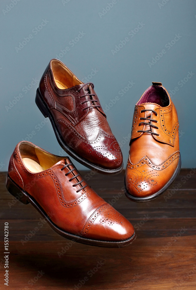 Fashion classical polished men's brown oxford brogues shades of brown oxford brogues.Conept flying shoes.Gray background