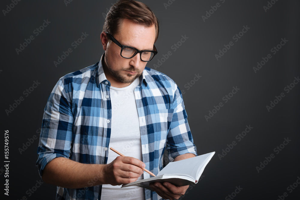 Ambitious careful man making some notes Ambitious careful man making some notes