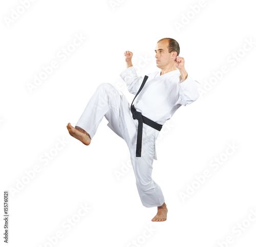 Blocks hands and kick leg is doing an athlete in karategi