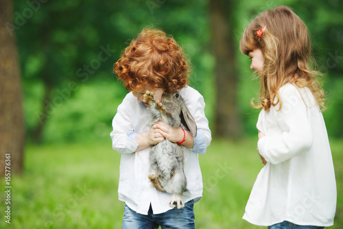 little boy and girl playing with rabbit © Aliaksei Lasevich