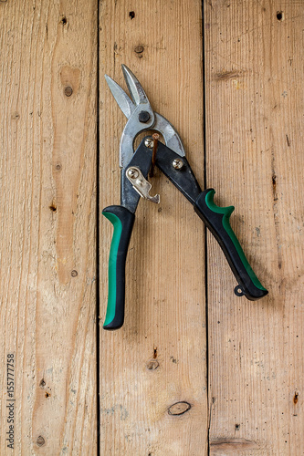 Old work tools hang on the wooden wall.